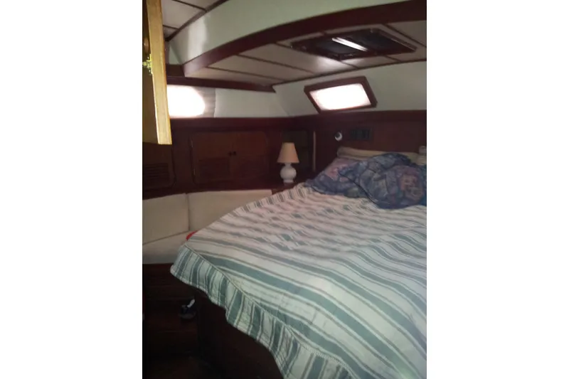 Slide: The Image of Cozy cabin interior of 1987 Tayana 52 sailboat with striped bedding and wooden accents. - 12