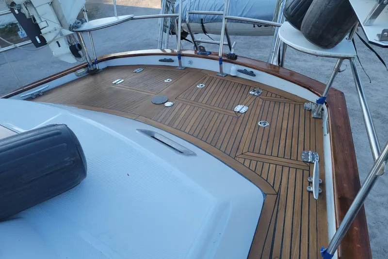 Slide: The Image of Teak deck of 1987 Tayana 52 sailboat, featuring polished wood and metal fittings. - 21