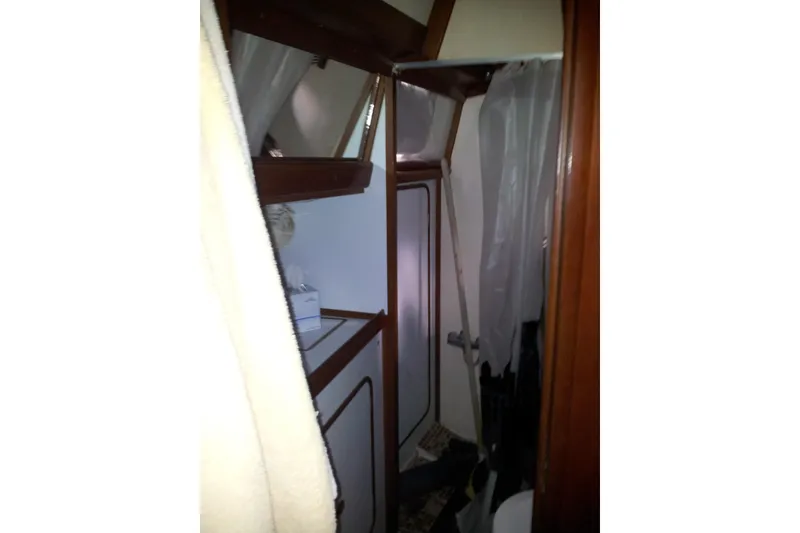 Slide: The Image of Interior of 1987 Tayana 52 sailboat bathroom with wooden accents and compact design. - 13