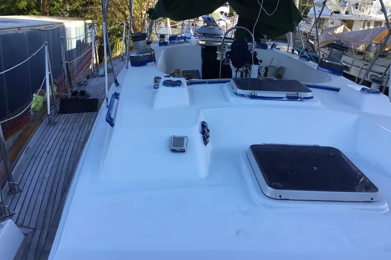 Slide: The Image of 1987 Tayana 52 sailboat deck with hatches and rigging in a marina setting. - 9