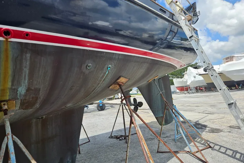 Slide: The Image of 1987 Tayana 52 sailboat on dry dock, showing hull and propeller maintenance. - 37