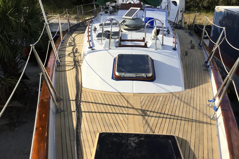 Slide: The Image of 1987 Tayana 52 sailboat deck with wooden finish and solar panel. - 20