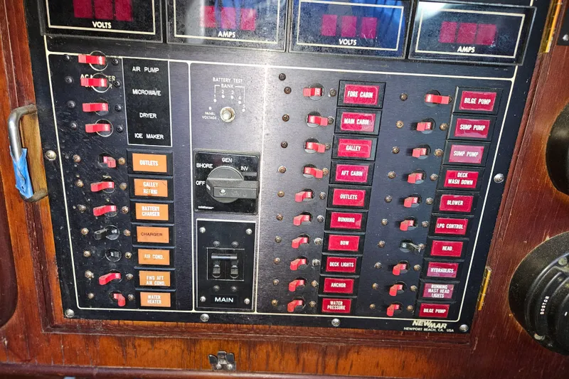 Slide: The Image of Electrical control panel on a 1987 Tayana 52 yacht, featuring various switches and indicators. - 22