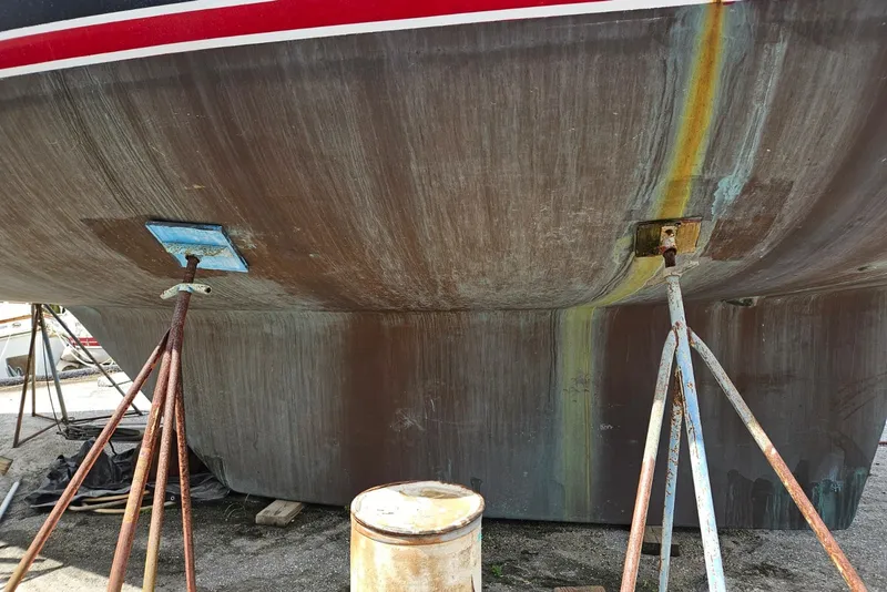 Slide: The Image of Bottom view of a 1987 Tayana 52 sailboat hull on stands, showing wear and rust. - 38