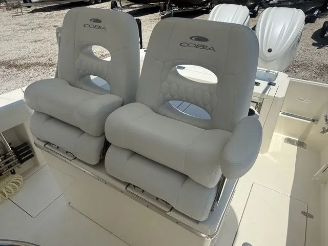 Slide: The Image of Two cushioned seats with Cobia logo on a boat, surrounded by light-colored deck. - 20