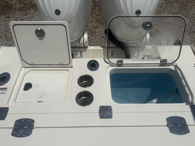 Slide: The Image of The image shows the stern of a Cobia 265 Open Center Console boat with two engines and a blue water compartment. - 28