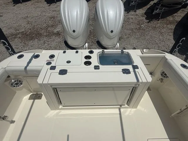 Slide: The Image of The image shows the stern of a Cobia 265 Open Center Console boat with dual engines and a work area with a sink. - 30