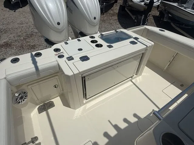 Slide: The Image of The image shows the cockpit of a 2025 Cobia 265 Open Center Console boat with dual engines. - 31