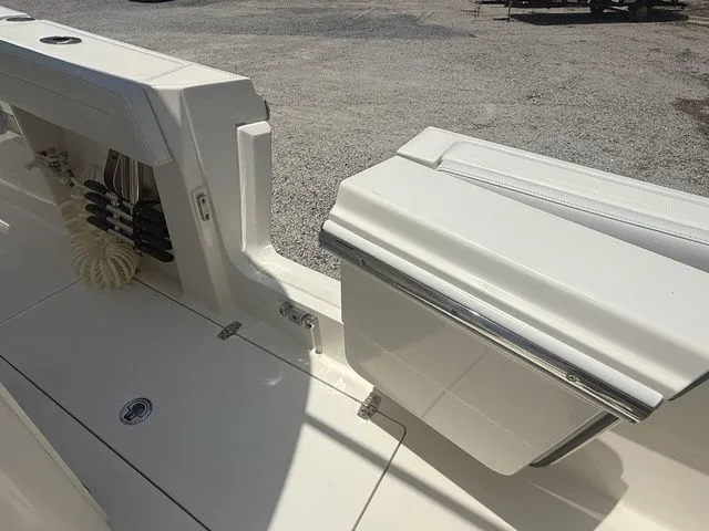 Slide: The Image of The image shows the deck of a 2025 Cobia 265 Open Center Console boat with storage space. - 26