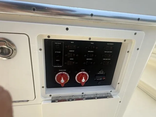 Slide: The Image of A control panel on a 2025 Cobia 265 Open Center Console boat with various switches and knobs. - 25
