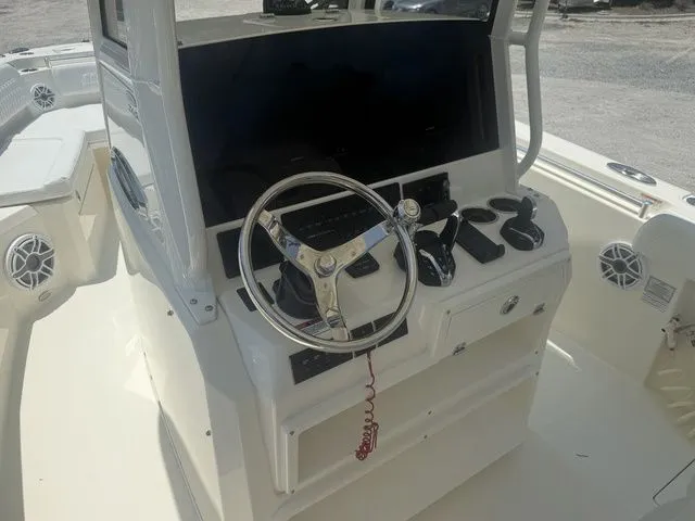 Slide: The Image of The image shows the helm of a Cobia 265 Open Center Console boat. It features a modern steering wheel and controls. - 19