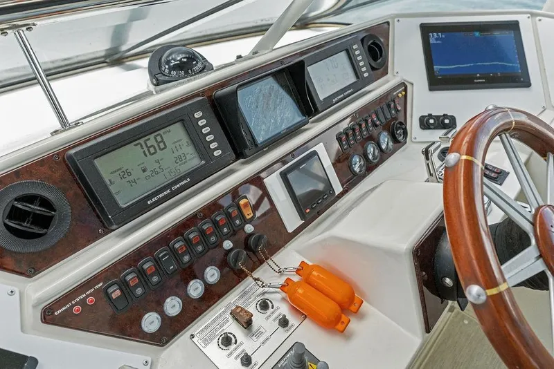 Slide: The Image of Cockpit of 2005 Marquis 65 MY yacht with navigation instruments and wooden steering wheel. - 63