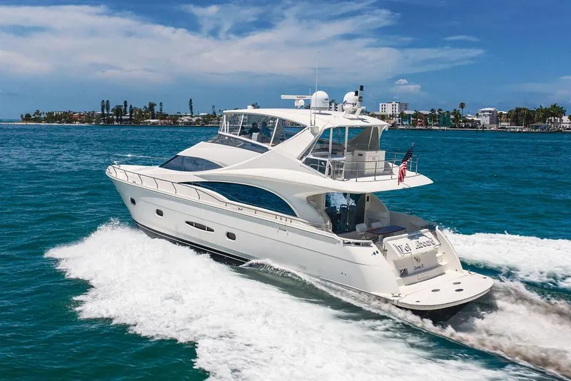 Slide: The Image of Luxurious 2005 Marquis 65 MY yacht cruising on clear blue waters near a coastal city. - 5