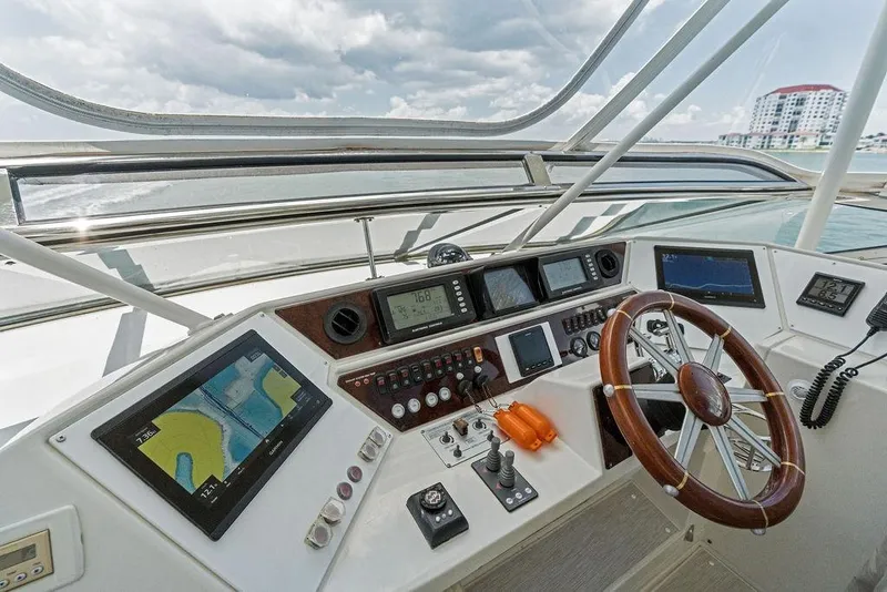 Slide: The Image of Helm of 2005 Marquis 65 MY yacht with navigation screens and wooden steering wheel. - 59
