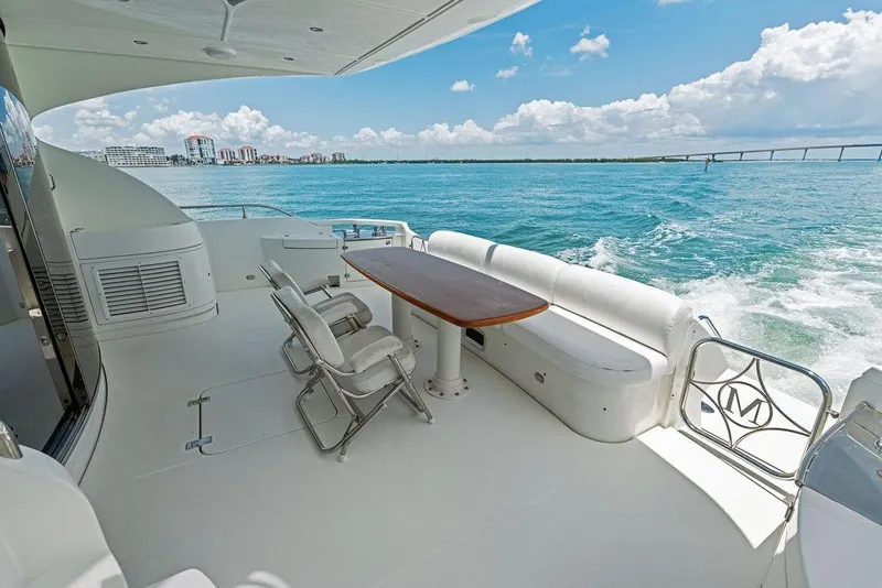 Slide: The Image of Luxurious 2005 Marquis 65 MY yacht deck with seating, table, and ocean view. - 37