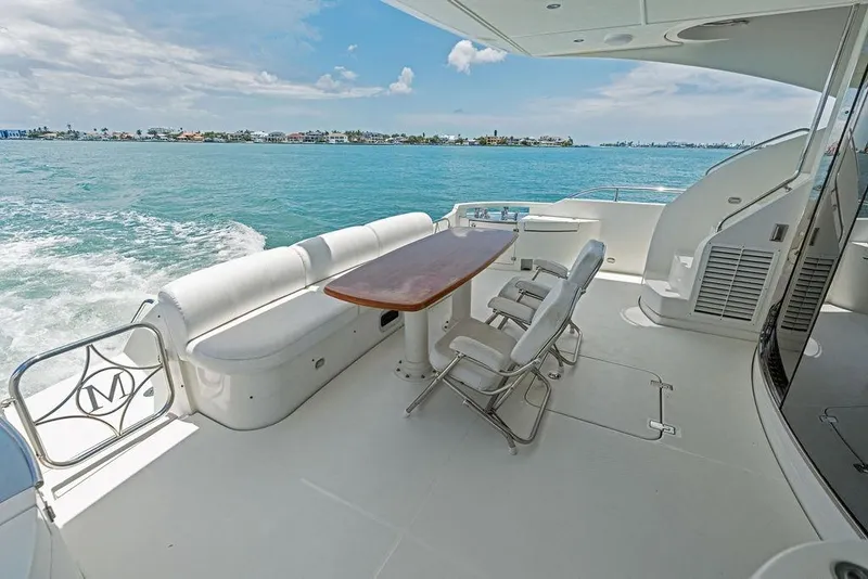 Slide: The Image of Luxurious 2005 Marquis 65 MY yacht deck with seating, table, and ocean view. - 36