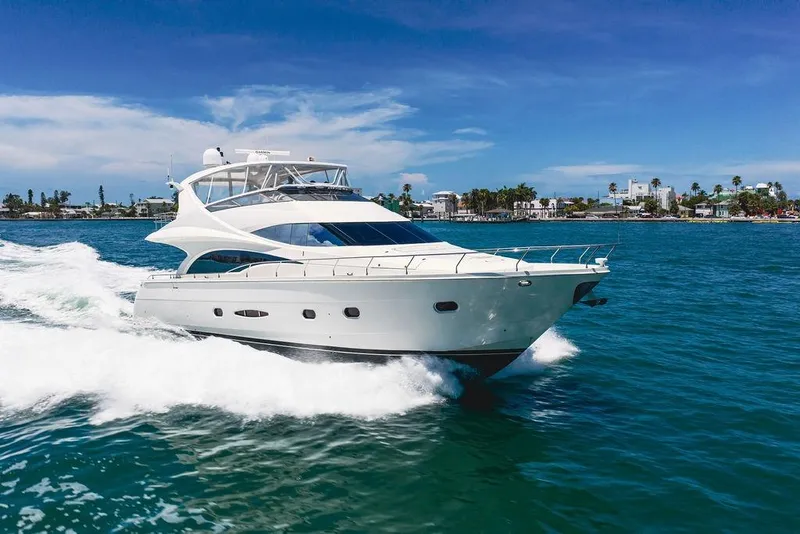 Slide: The Image of 2005 Marquis 65 MY yacht cruising on blue ocean near coastal cityscape. - 16