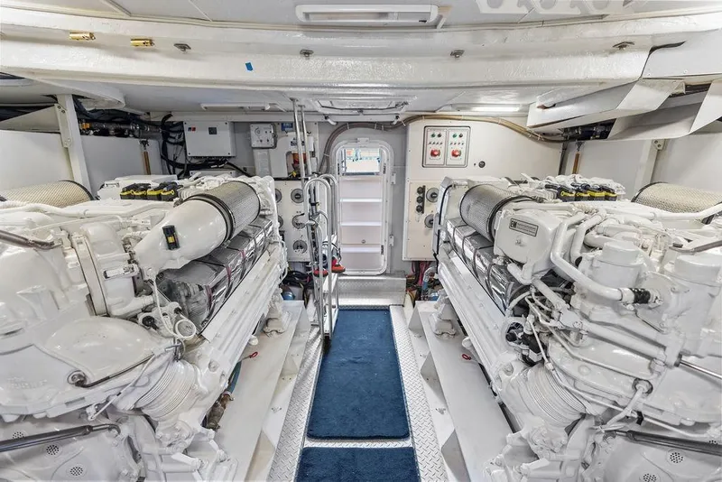 Slide: The Image of Engine room of a 2005 Marquis 65 MY yacht, featuring dual engines and control panels. - 87