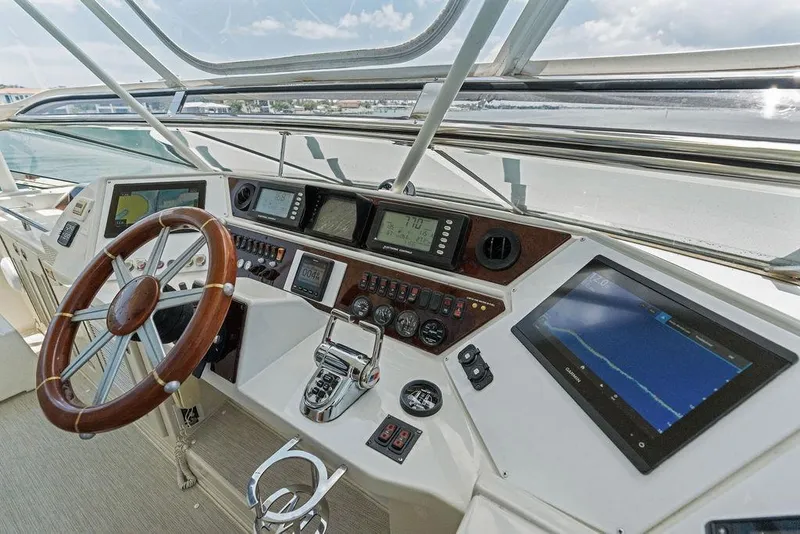 Slide: The Image of Cockpit of 2005 Marquis 65 MY yacht with navigation instruments and wooden steering wheel. - 62