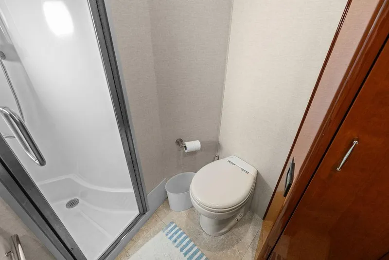 Slide: The Image of Bathroom in 2005 Marquis 65 MY yacht with shower, toilet, and wooden cabinetry. - 24