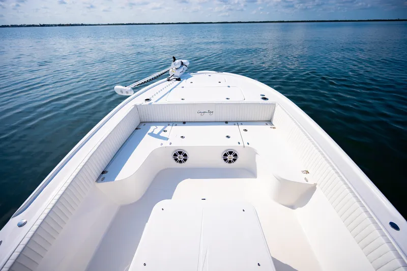 Slide: The Image of 2023 Canyon Bay 28h boat on calm water, showcasing spacious deck and sleek design. - 14