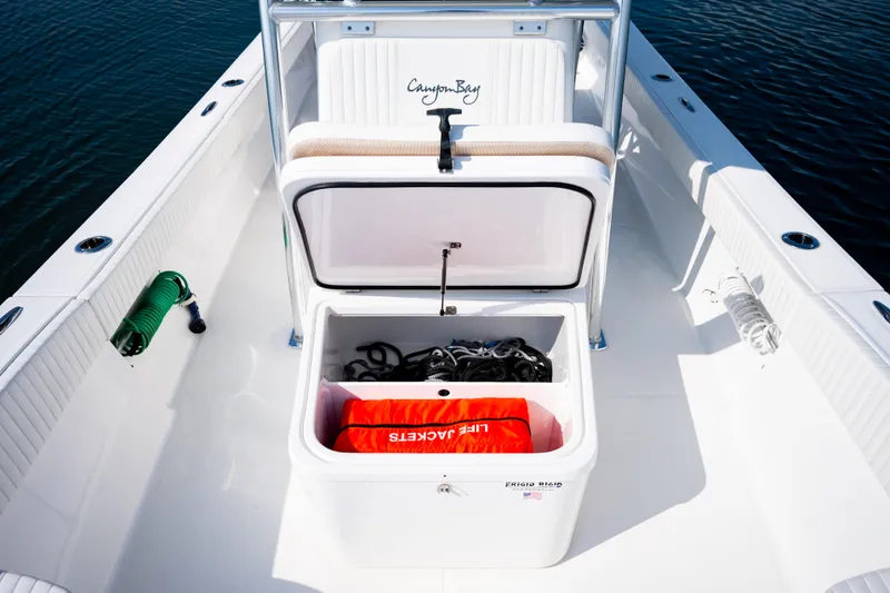 Slide: The Image of 2023 Canyon Bay 28h boat with open storage compartment, life jackets, and ropes. - 28