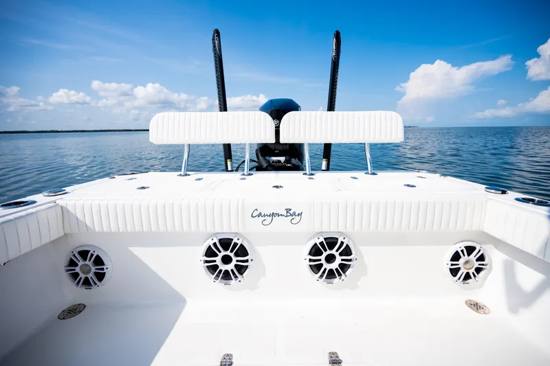 Slide: The Image of 2023 Canyon Bay 28h boat interior with speakers, on calm ocean under blue sky. - 44