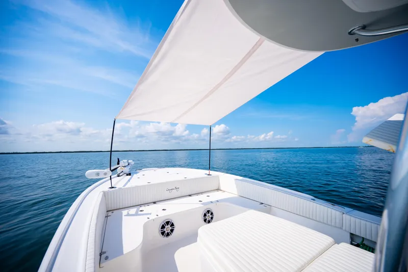 Slide: The Image of 2023 Canyon Bay 28h boat with canopy on calm blue water under clear sky. - 19