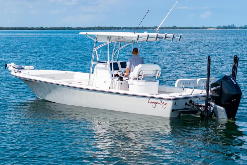 Slide: The Image of 2023 Canyon Bay 28h boat on calm blue water, featuring a sleek design and powerful engine. - 1