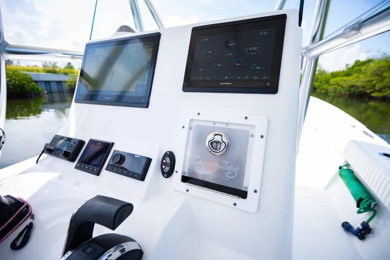 Slide: The Image of 2023 Canyon Bay 28h boat dashboard with Garmin displays and control panel. - 30