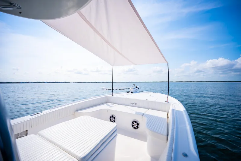 Slide: The Image of 2023 Canyon Bay 28h boat with sunshade on calm water under blue sky. - 20