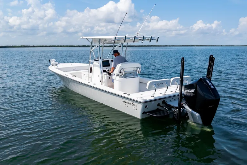 Slide: The Image of 2023 Canyon Bay 28h boat on calm water, featuring a Mercury engine. - 8
