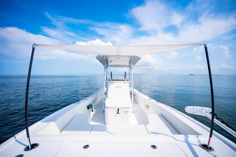Slide: The Image of 2023 Canyon Bay 28h boat on open water under clear blue sky. - 22