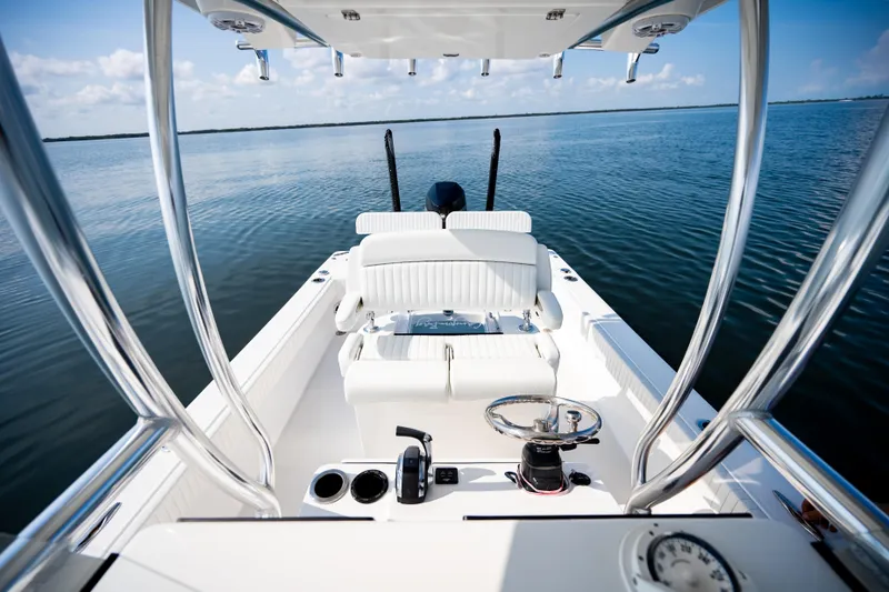 Slide: The Image of 2023 Canyon Bay 28h boat interior with steering wheel, white seating, and open water view. - 35