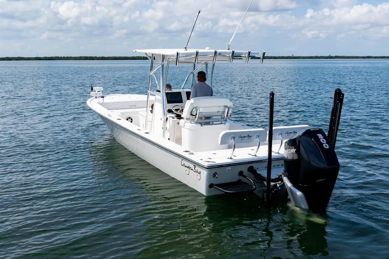 Slide: The Image of 2023 Canyon Bay 28h boat cruising on calm waters under a partly cloudy sky. - 5