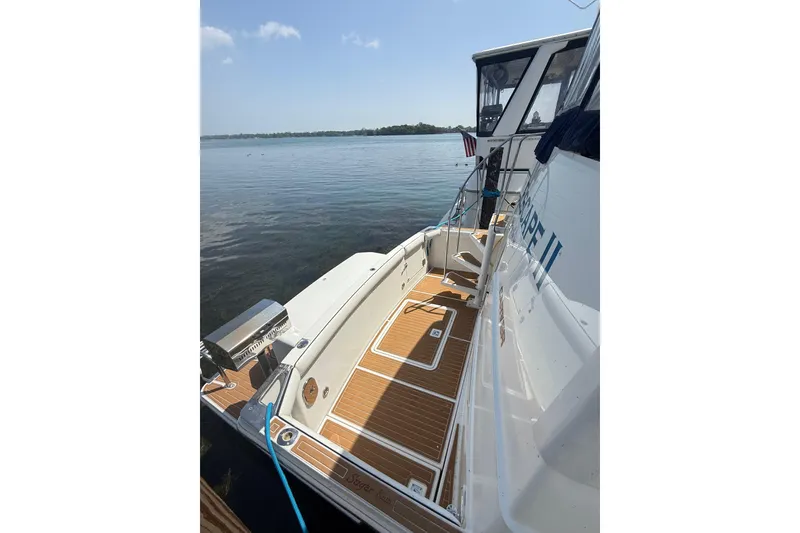 Slide: The Image of 1996 Carver 400 Cockpit Motor Yacht docked, featuring spacious deck and serene water view. - 13