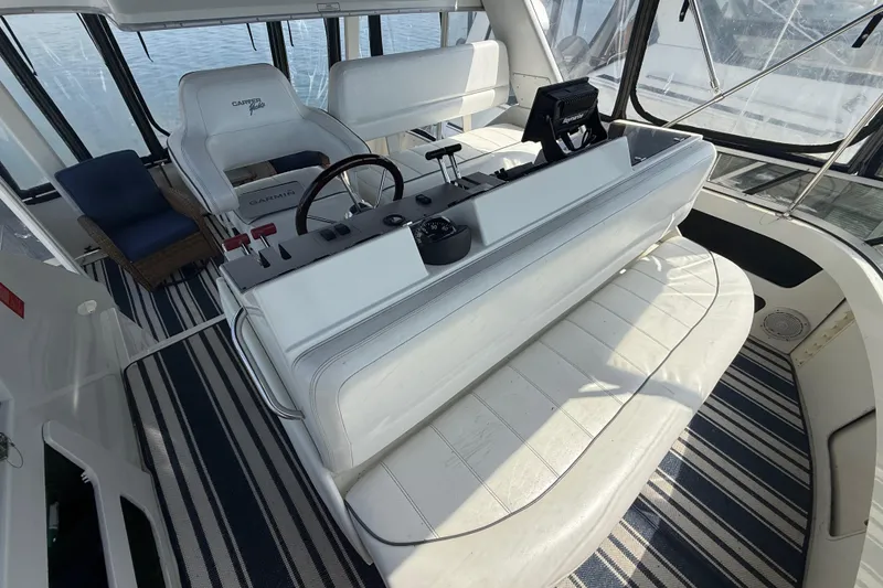 Slide: The Image of 1996 Carver 400 Cockpit Motor Yacht interior with helm, seating, and striped flooring. - 21