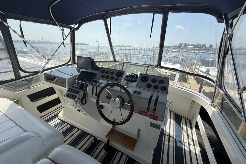 Slide: The Image of 1996 Carver 400 Cockpit Motor Yacht helm with marina view, featuring navigation controls. - 18