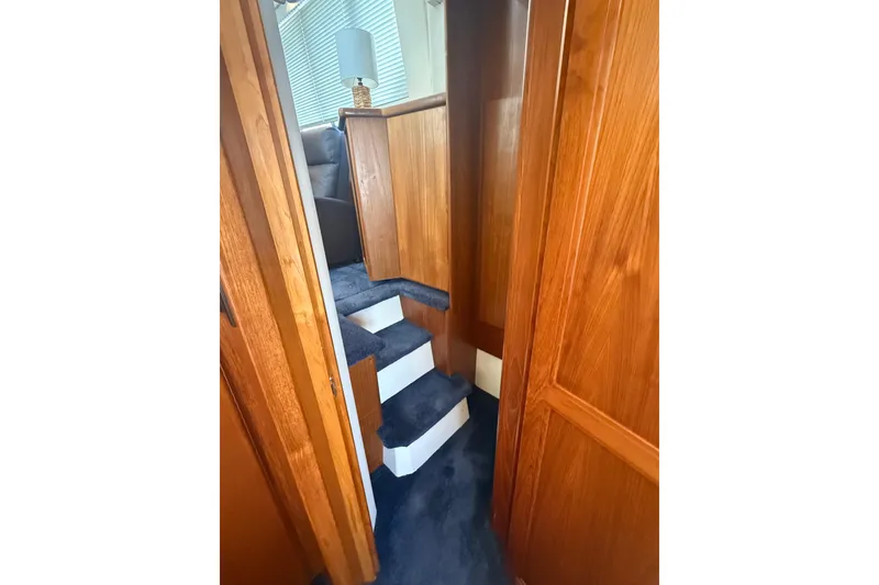 Slide: The Image of Interior view of 1996 Carver 400 Cockpit Motor Yacht with wooden paneling and carpeted stairs. - 45