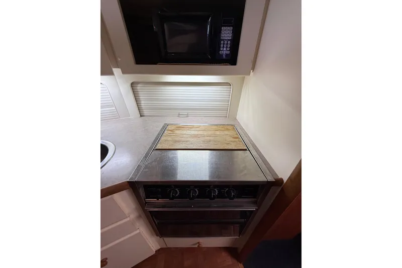 Slide: The Image of Compact kitchen area in a 1996 Carver 400 Cockpit Motor Yacht with stove and microwave. - 37