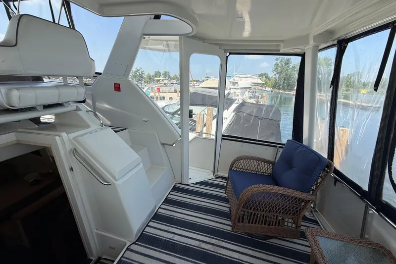 Slide: The Image of Interior of 1996 Carver 400 Cockpit Motor Yacht with seating and marina view. - 17