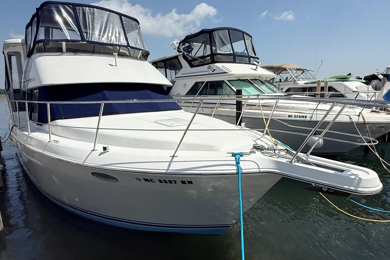 Slide: The Image of 1996 Carver 400 Cockpit Motor Yacht docked at marina under clear sky. - 4