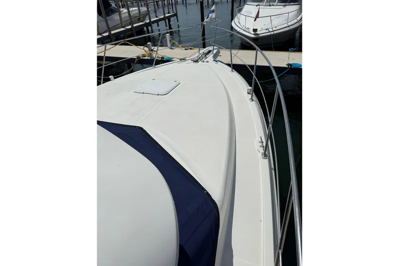 Slide: The Image of 1996 Carver 400 Cockpit Motor Yacht docked, showcasing sleek deck design and railing. - 8