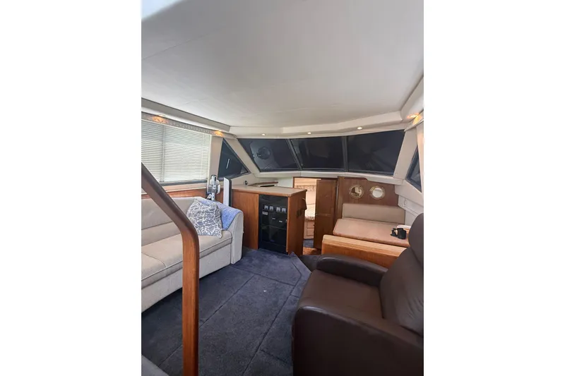 Slide: The Image of Interior of 1996 Carver 400 Cockpit Motor Yacht, featuring cozy seating and elegant wood finishes. - 28