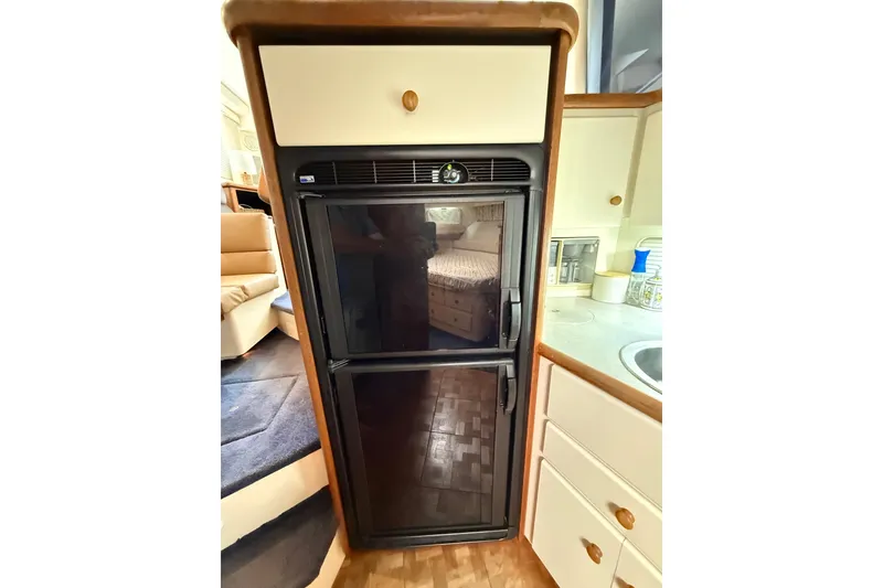 Slide: The Image of 1996 Carver 400 Cockpit Motor Yacht interior with compact black refrigerator. - 35
