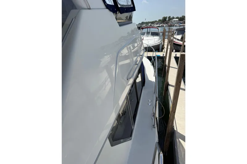 Slide: The Image of Side view of a 1996 Carver 400 Cockpit Motor Yacht docked at a marina. - 9