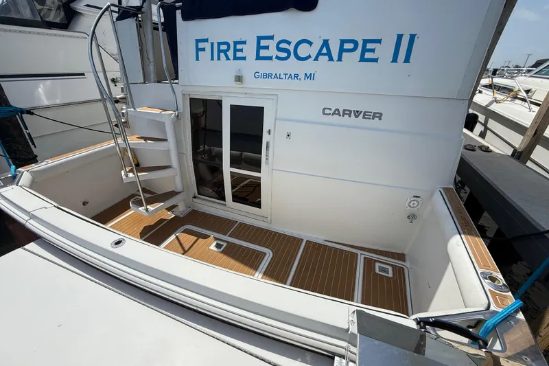 Slide: The Image of 1996 Carver 400 Cockpit Motor Yacht docked, featuring teak flooring and spiral staircase. - 12