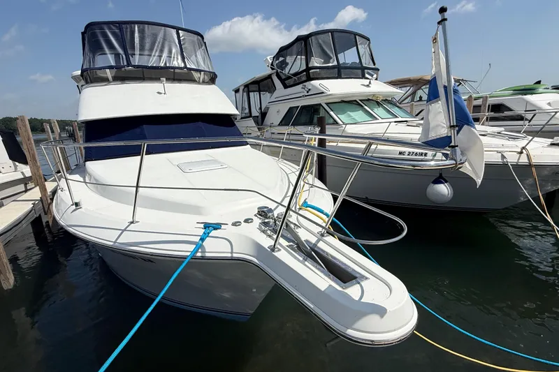 Slide: The Image of 1996 Carver 400 Cockpit Motor Yacht docked at marina under clear sky. - 2
