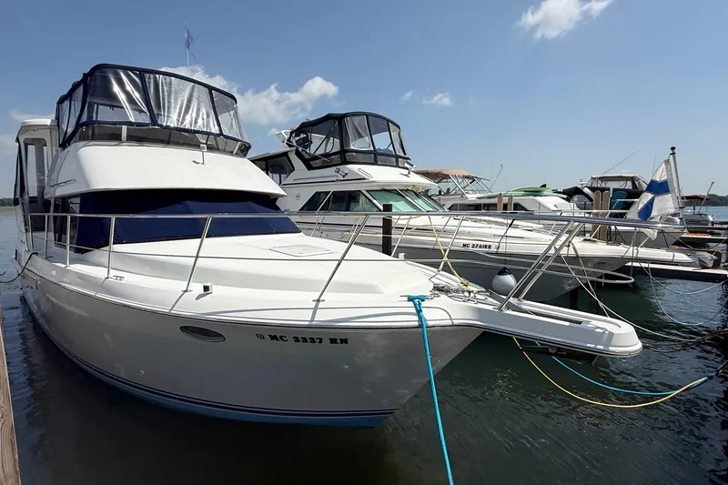 Slide: The Image of 1996 Carver 400 Cockpit Motor Yacht docked at marina under clear sky. - 3