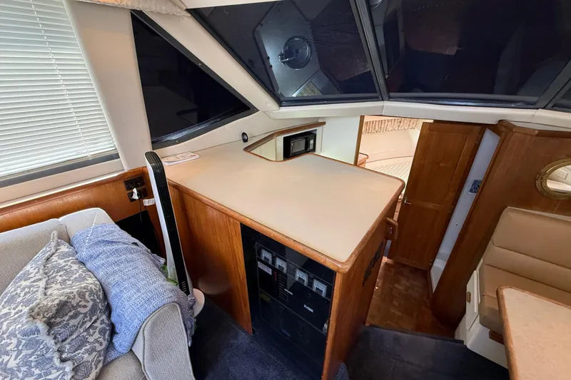 Slide: The Image of Interior of 1996 Carver 400 Cockpit Motor Yacht with cozy seating and wooden cabinetry. - 31